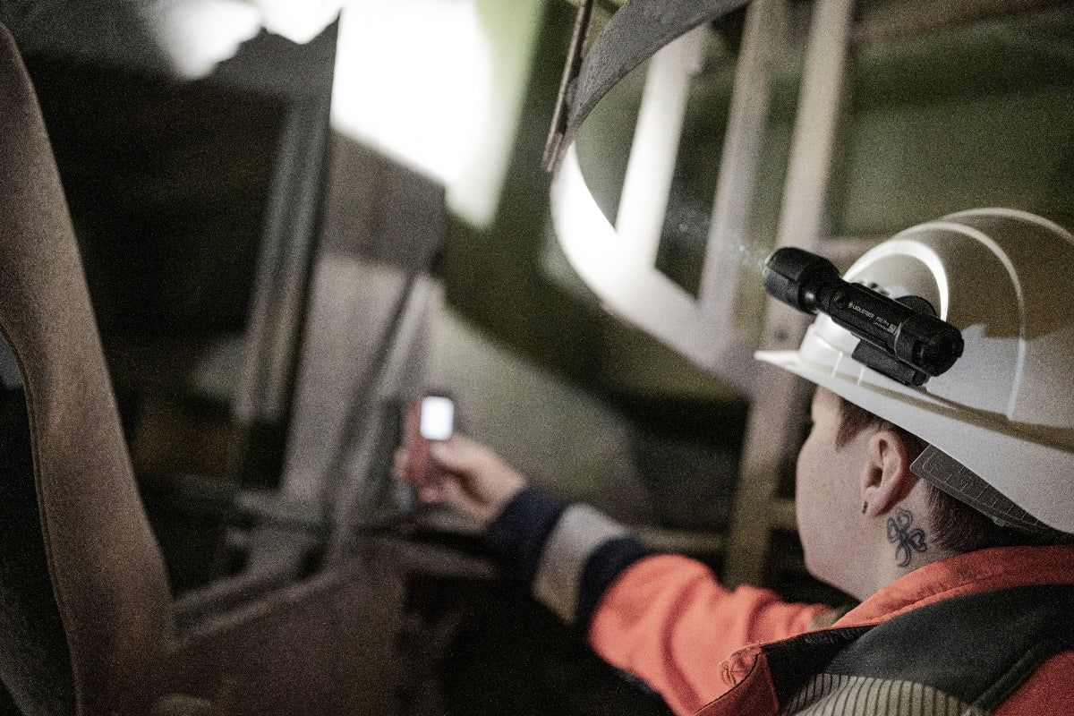 P5R Pro Torch mounted on a safety helmet worn by a worker at an industrial site