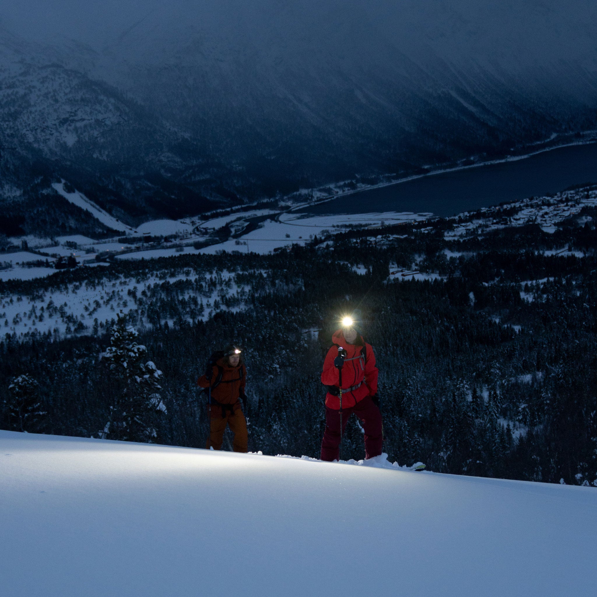 H19R Signature Headlamp worn by a hiker in a snowy mountain night scene with a bright beam; another climber in an orange jacket nearby