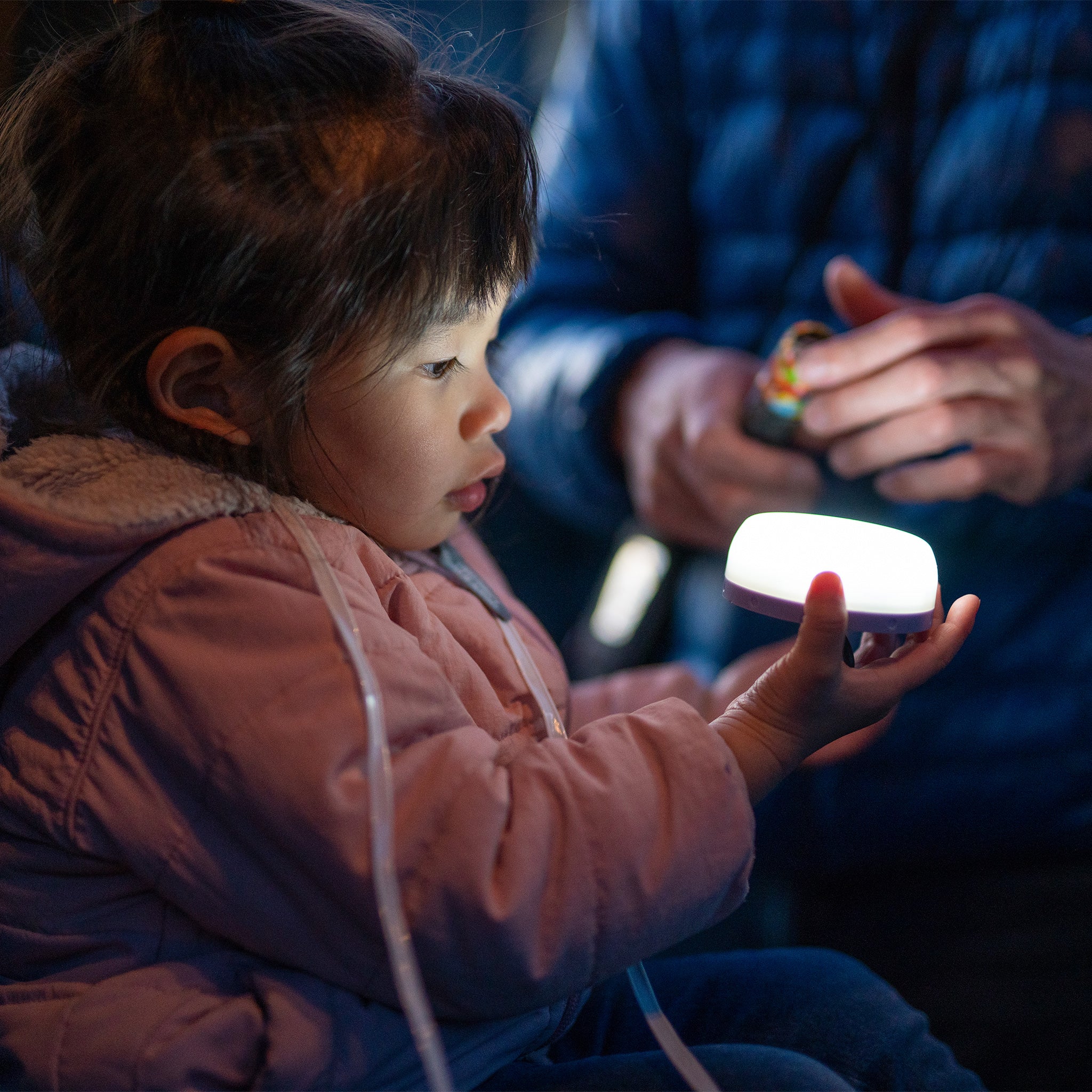 Kidcamp6 Lantern held by a child with a glowing compact lantern adult in background
