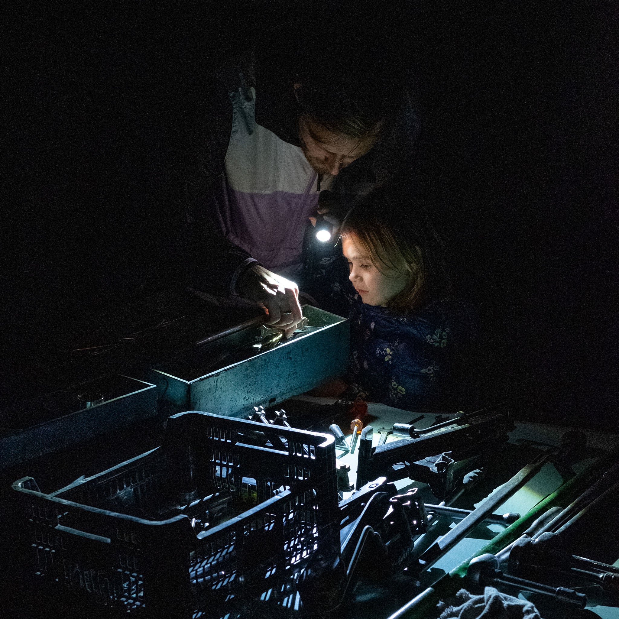 P6 Core Torch used in a dark workshop lighting a toolbox as two people inspect tools