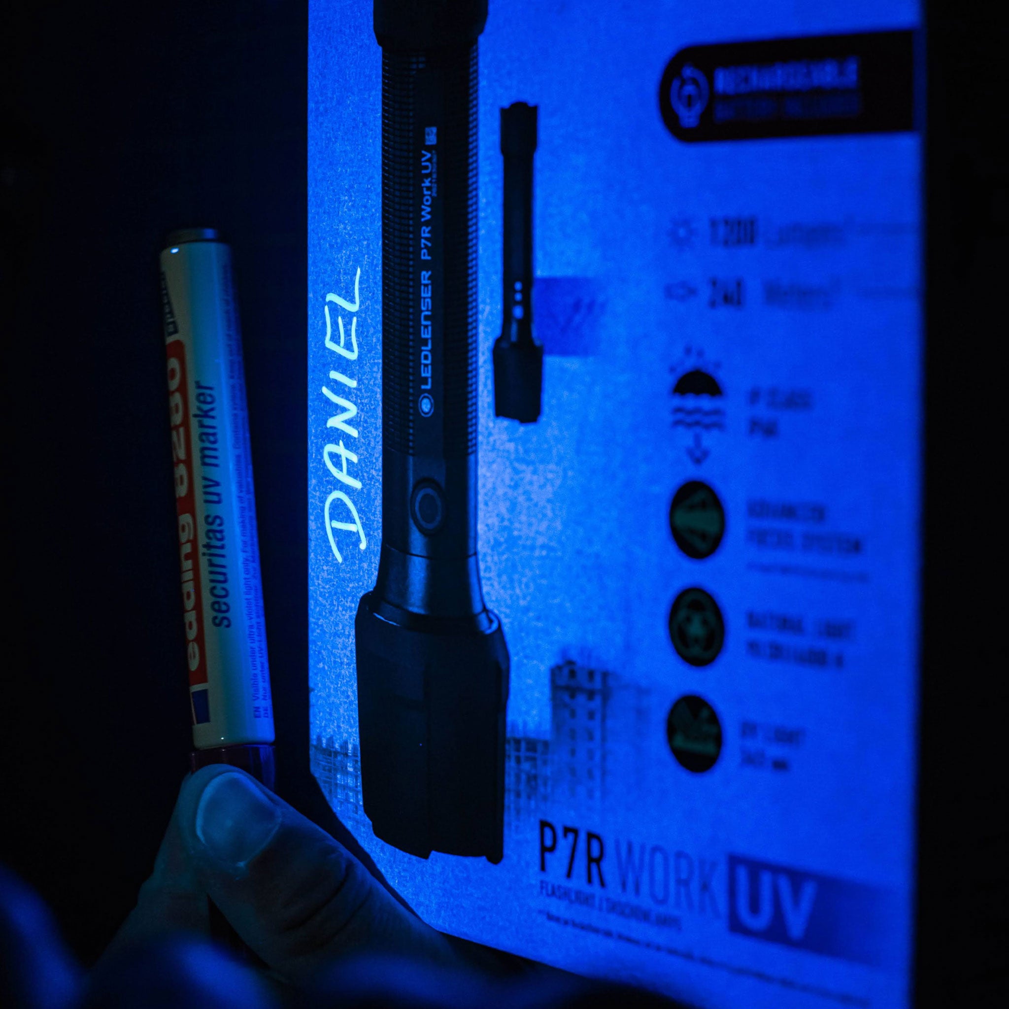 Ledlenser P7R Work UV Torch packaging image showing a black rechargeable torch upright with blue illumination