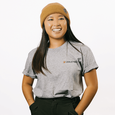 Mulga x Ledlenser Unisex Tee worn by a model showcasing a grey t shirt with the Ledlenser logo on the chest and a mustard beanie