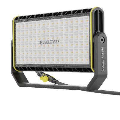 AF12C Work Floodlight featuring a rectangular LED panel with a grid of LEDs black grey housing with yellow trim mounted on a stand with power cable attached