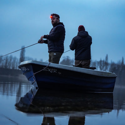 HF8R Signature Headlamp worn by man on a fishing boat at dusk with a red front light