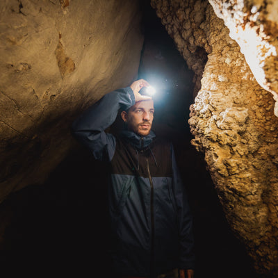 HF8R Signature Headlamp worn by a man in a cave with the headlamp lighting the rocky walls