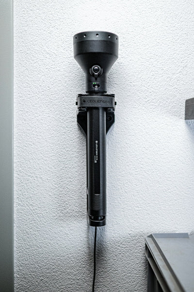 Ledlenser P21R Torch mounted upright on wall bracket; black high‑output rechargeable searchlight style