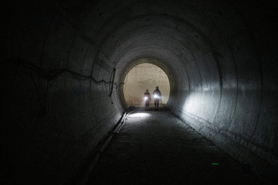 P21R Torch two workers in a dark tunnel with bright Ledlenser headlamps at the tunnel entrance