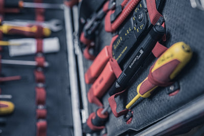 Ledlenser P4 torch in a tool kit tray among red screwdrivers shown from a side angle