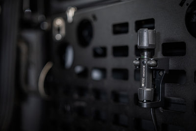 Ledlenser P5R Pro Torch mounted on a clamp bracket attached to a dark perforated panel in an industrial setting
