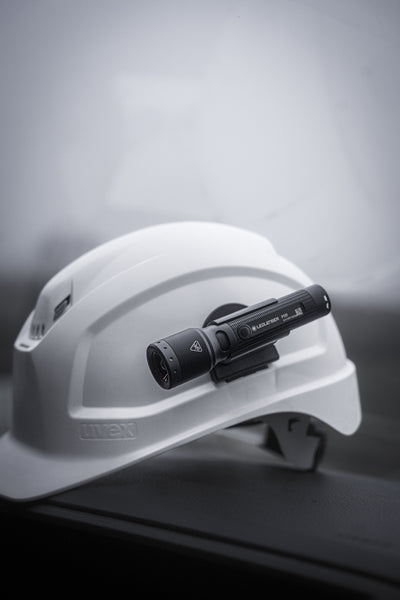 Ledlenser P5R Torch mounted on a white safety helmet close‑up side view of the compact flashlight for professional use