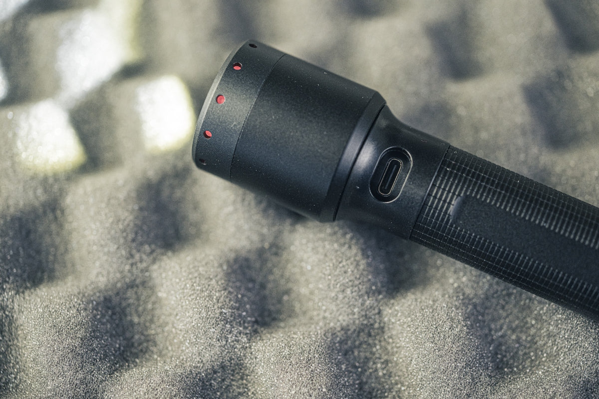 Ledlenser P6R Torch close view of black aluminum head with red indicator dots and USB‑C charging port along the grip face on