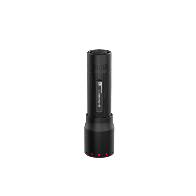 Ledlenser P7 Torch standing upright in dark with textured black body and base dock; red status lights visible