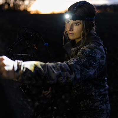 Ledlenser MH8 Powercase Combo Headlamp & Charging Case worn on head with charging case nearby in a dark outdoor scene