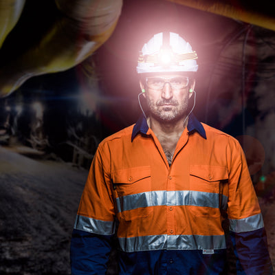 Ledlenser EXH8R headlamp worn by a worker in safety gear with a helmet light on and an orange high visibility jacket