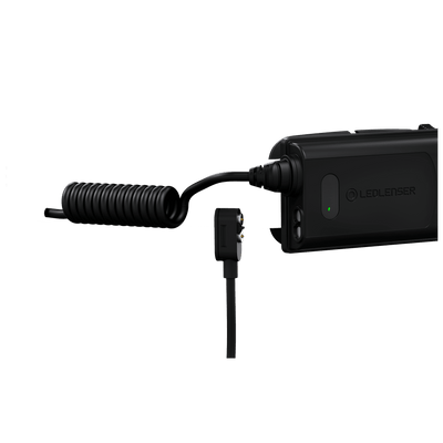 Ledlenser H5R Core Headlamp battery pack connected to a coiled charging cable with plug and green indicator light visible on the unit