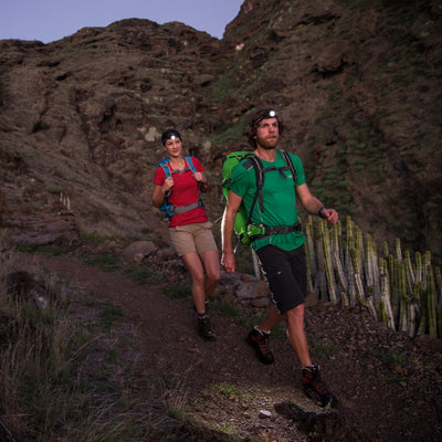 Ledlenser H7 2 Headlamp worn by a man on a rocky trail at dusk with a woman behind him both wearing headlamps