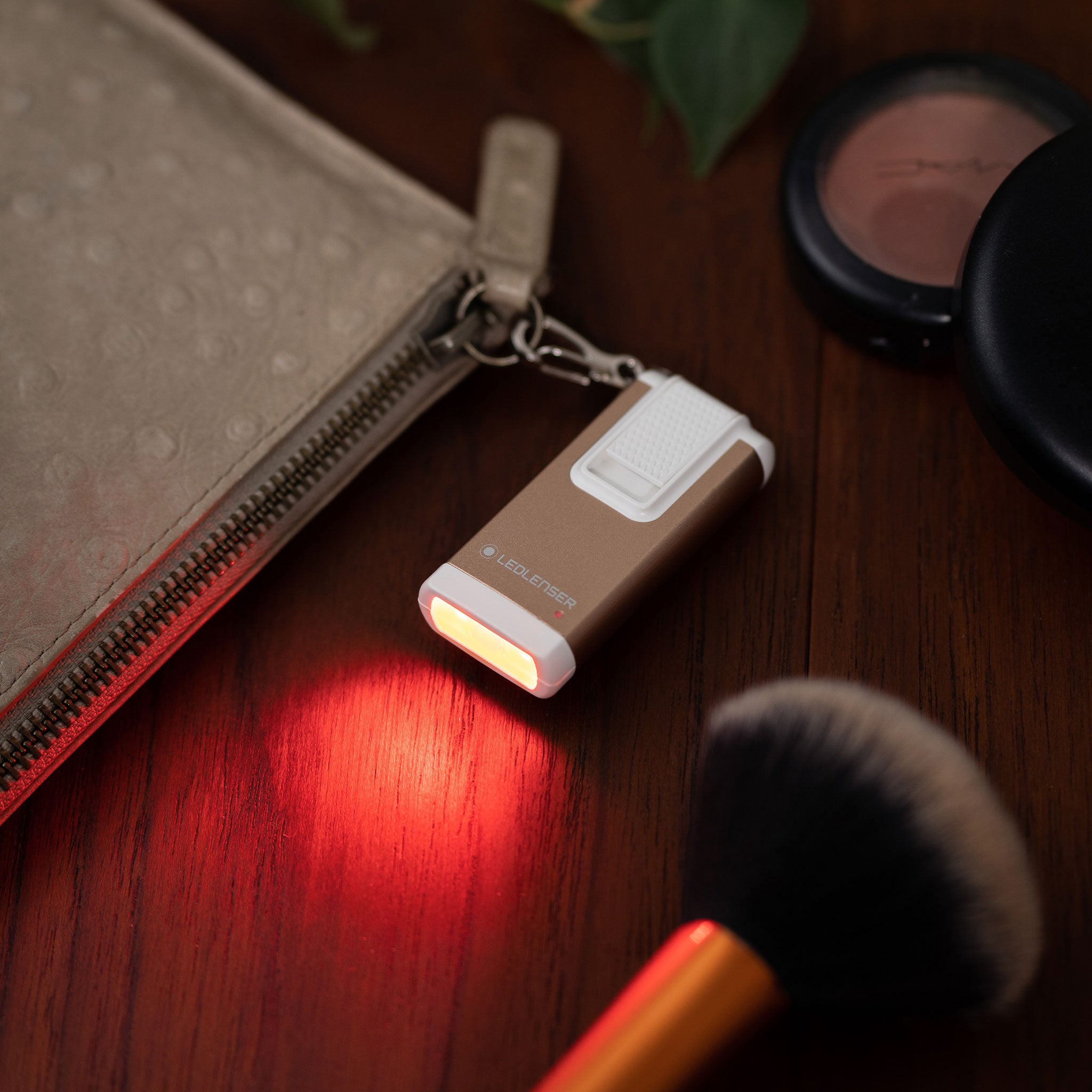 K6R Keychain Light beige Ledlenser rechargeable keyring flashlight with white switch shown emitting red light
