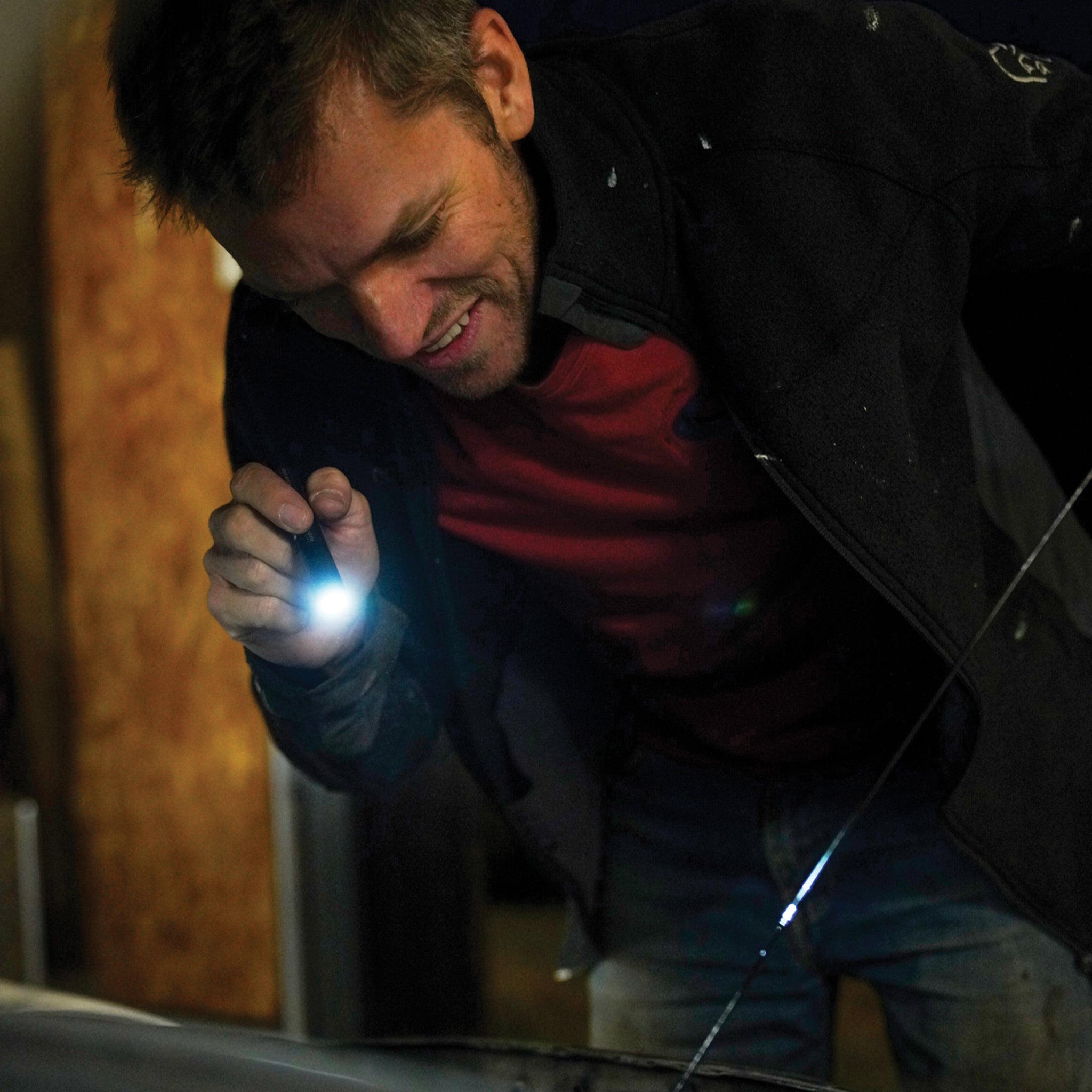 Ledlenser P2R Core Torch being held by a man in a dark jacket with a blue beam visible