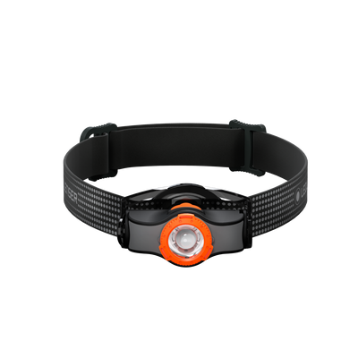MH3 Headlamp on adjustable black head strap with orange front bezel worn on head for hands free lighting