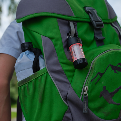 ML4 Lantern attached to a green backpack strap compact portable Ledlenser lantern clipped for easy access