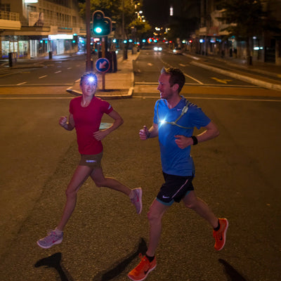 NEO6R Rechargeable Headlamp worn by runner; night urban street scene with two runners and bright headlamp beams