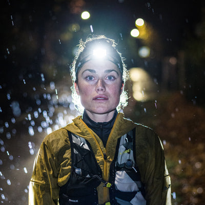 NEO1R Running Headlamp being worn outdoors at night in the rain with the headlamp on