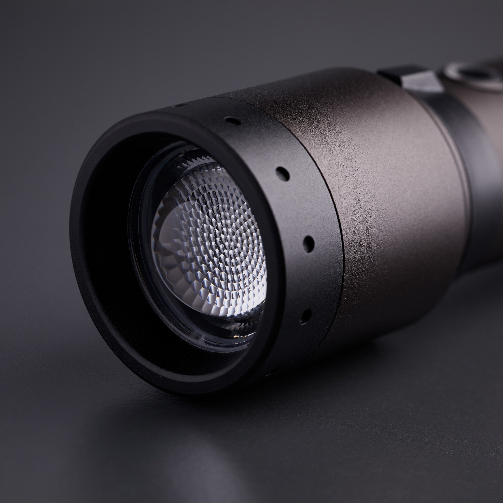 P7R Signature Torch close up of front lens and textured reflector on black metallic body