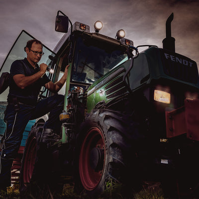 Ledlenser P7 Battery Operated Torch being used by a technician inspecting a green Fendt tractor at dusk