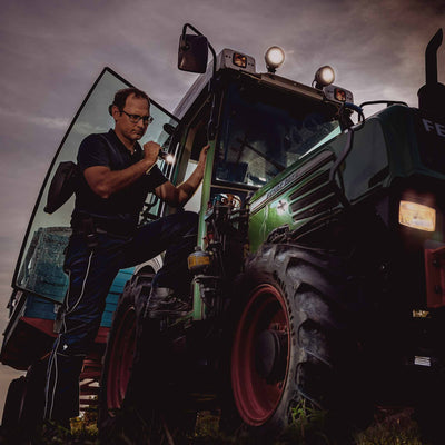 P2 Battery Operated Torch being used by a technician on a tractor at dusk illuminating the work area