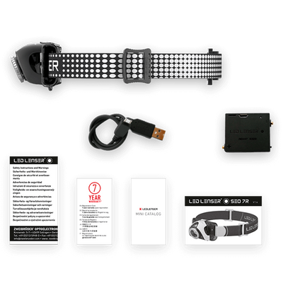 Ledlenser SEO7R Headlamp with perforated strap USB charging cable battery pack and included manuals on a black background